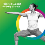 An adult woman practices yoga in a warrior pose indoors.
