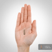A capsule measuring 0.917 inches or 2.329 cm rests on a hand.